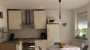 Una cucina compatta con zona pranzo, dotata di fornello, forno e microonde.