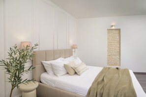 Une chambre à coucher avec un lit, des lampes de chevet, un luminaire fixé au mur, un élément décoratif texturé sur un mur et une plante en pot.