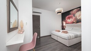A modern bedroom with a large bed, a chair, a mirror, and a wall-mounted air conditioner.