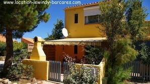 A yellow house with a satellite dish, a fenced yard, and a small garden. - Grd T3 comfortable, bikes / hammock, pond edge, near beach, quiet (Le Barcarès)
