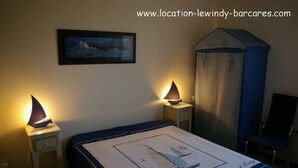 A bedroom with a bed, two bedside lamps, a canopy bed, a chair, and a framed picture on the wall. - Grd T3 comfortable, bikes / hammock, pond edge, near beach, quiet (Le Barcarès)