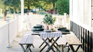 A covered outdoor dining area with a wooden table set for four, surrounded by white chairs, under a white pergola. - ★ Seen in 250 Articles ★ 1min → Town ★ Private ★ Great Kitchen ★ Luxury Home ★ (Round Top)