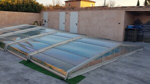 A rooftop with large glass enclosures, a green artificial turf, and a wall with doors and a small building. - 50m2 of silence in the heart of Vitrolles (Vitrolles)