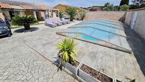 A swimming pool with lounge chairs, a car, and a building with a tiled roof. - 50m2 of silence in the heart of Vitrolles (Vitrolles)