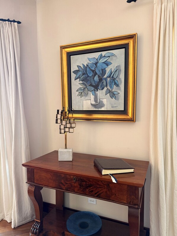A wooden desk with a framed artwork, a small sculpture, and a book.
