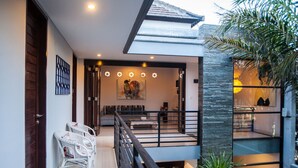 Een modern interieur met een trap, een zithoek en uitzicht op de omgeving.