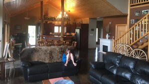 A spacious living area with a high ceiling, a fireplace, and a bar area with wooden shelves. - Stunning Post and Beam Home with the best views in the valley, wheelchair acc. (Penticton)