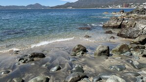 A rocky beach with clear water and distant mountains. - Beautiful home with private beach just for rest and relaxation. (Manzanillo)