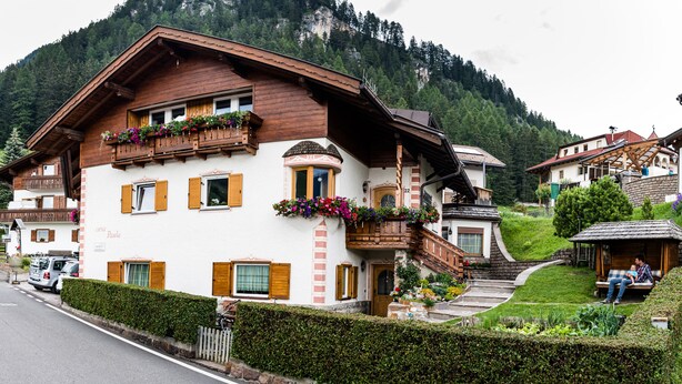 A traditional chalet with wooden balconies, a stone staircase, and a view of a mountainous landscape. - Ski and hiking adventure in the immediate vicinity, away from the crowds, yet close to the center (Selva Gardena - Wolkenstein in Gröden)