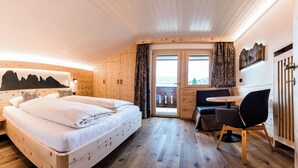 A wooden room with a bed, a desk, and a view of the outdoors. - Ski and hiking adventure in the immediate vicinity, away from the crowds, yet close to the center (Selva Gardena - Wolkenstein in Gröden)