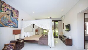 Un dormitorio espacioso con una cama grande, una mesita de noche, una silla de madera, un cuadro en la pared y un televisor en la pared.