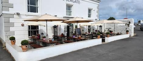 A building named 'The Seagate' with outdoor seating and umbrellas.