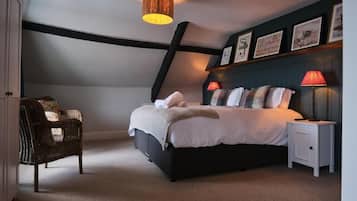 Un dormitorio con cama, lámparas de noche, una silla y una lámpara de techo.