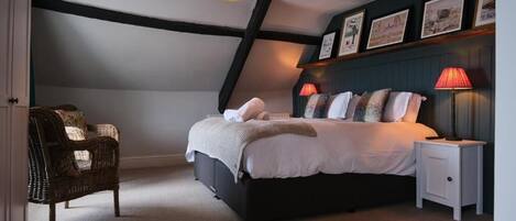 A bedroom with a bed, bedside lamps, a chair, and a ceiling light fixture.