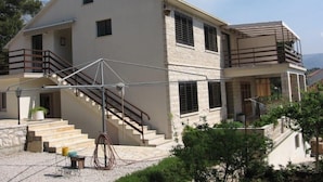 A two-story building with a balcony, a staircase, and a small outdoor seating area. - Studio apartment in Orebić with Seaview, Terrace, Air condition, WIFI (4669-5) (Orebic)