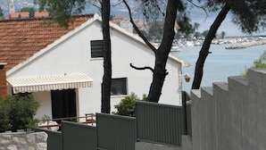 A coastal house with a white exterior, a tiled roof, and a view of the sea. - Studio apartment in Orebić with Seaview, Terrace, Air condition, WIFI (4669-5) (Orebic)
