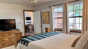 A bedroom with a bed, a TV on a wooden dresser, a ceiling fan, and a window with curtains. - Maggie May @ Tenkiller - 2 minutes to boat ramp & state park! (Vian)