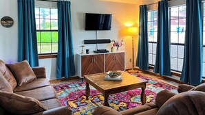 A living room with a sofa, a coffee table, a TV, and a cabinet. - Maggie May @ Tenkiller - 2 minutes to boat ramp & state park! (Vian)