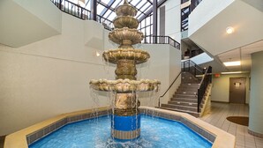 A multi-tiered fountain in a pool area with a staircase in the background. - Phoenix VI #606 - Resort Style complex owner's Beach Chairs Included in Rental (Orange Beach)