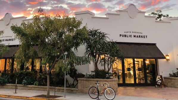 A building with a sign reading "Santa Barbara Public Market" and a bicycle parked outside.