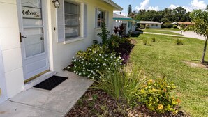 A residential house with a front porch, a welcome sign, and a well-maintained lawn. - Get To the Beach!  Only 5 miles to Siesta Key Beach! (Sarasota)