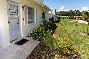A residential house with a front porch, a welcome sign, and a well-maintained lawn. - Get To the Beach!  Only 5 miles to Siesta Key Beach! (Sarasota)
