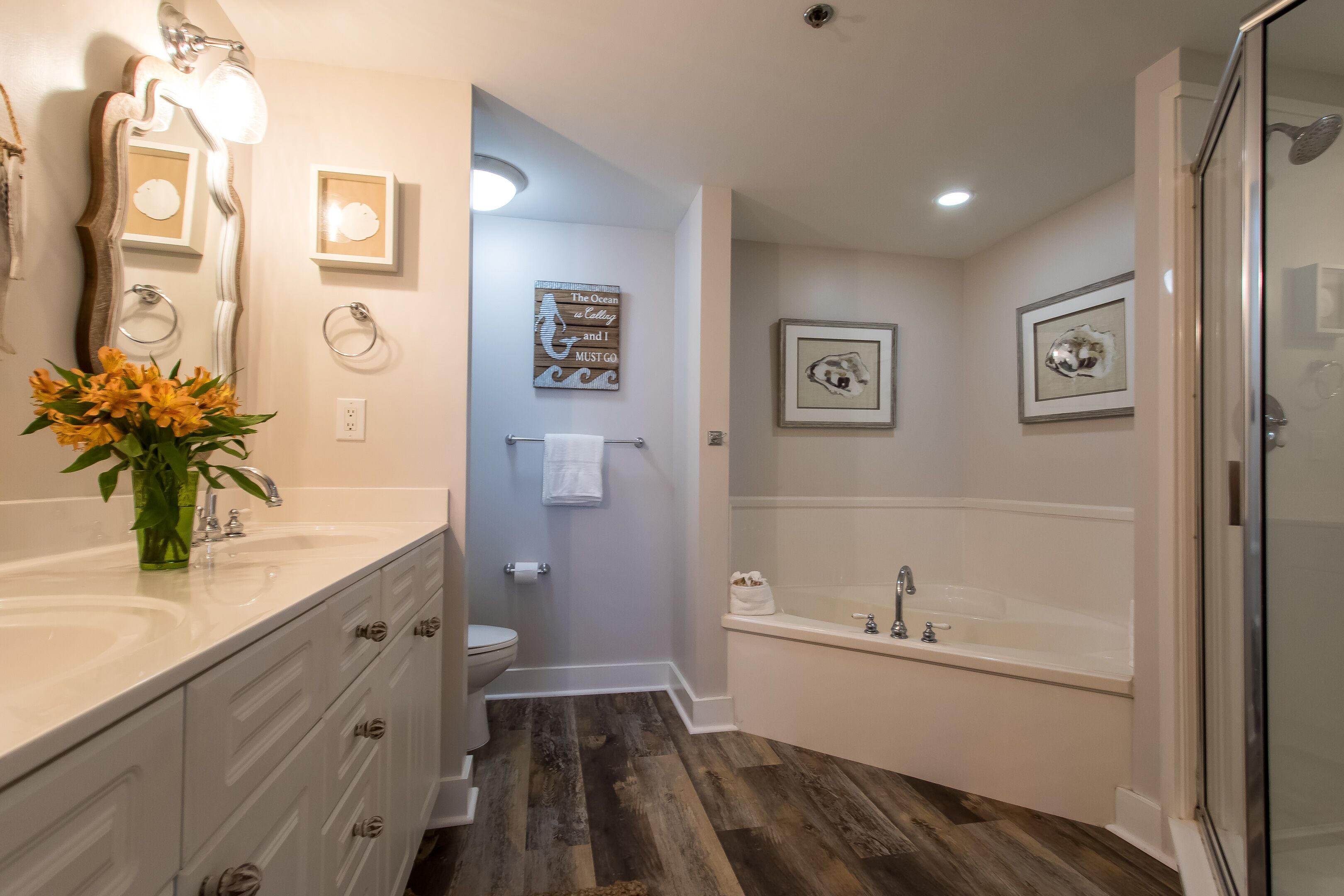 A modern bathroom with a vanity, sink, and bathtub.