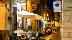 An outdoor café with tables and chairs, a sign for 'Osteria Senza Fretta', and a pedestrian area sign. - Osteria Senza Fretta Affittacamere (Cuneo)
