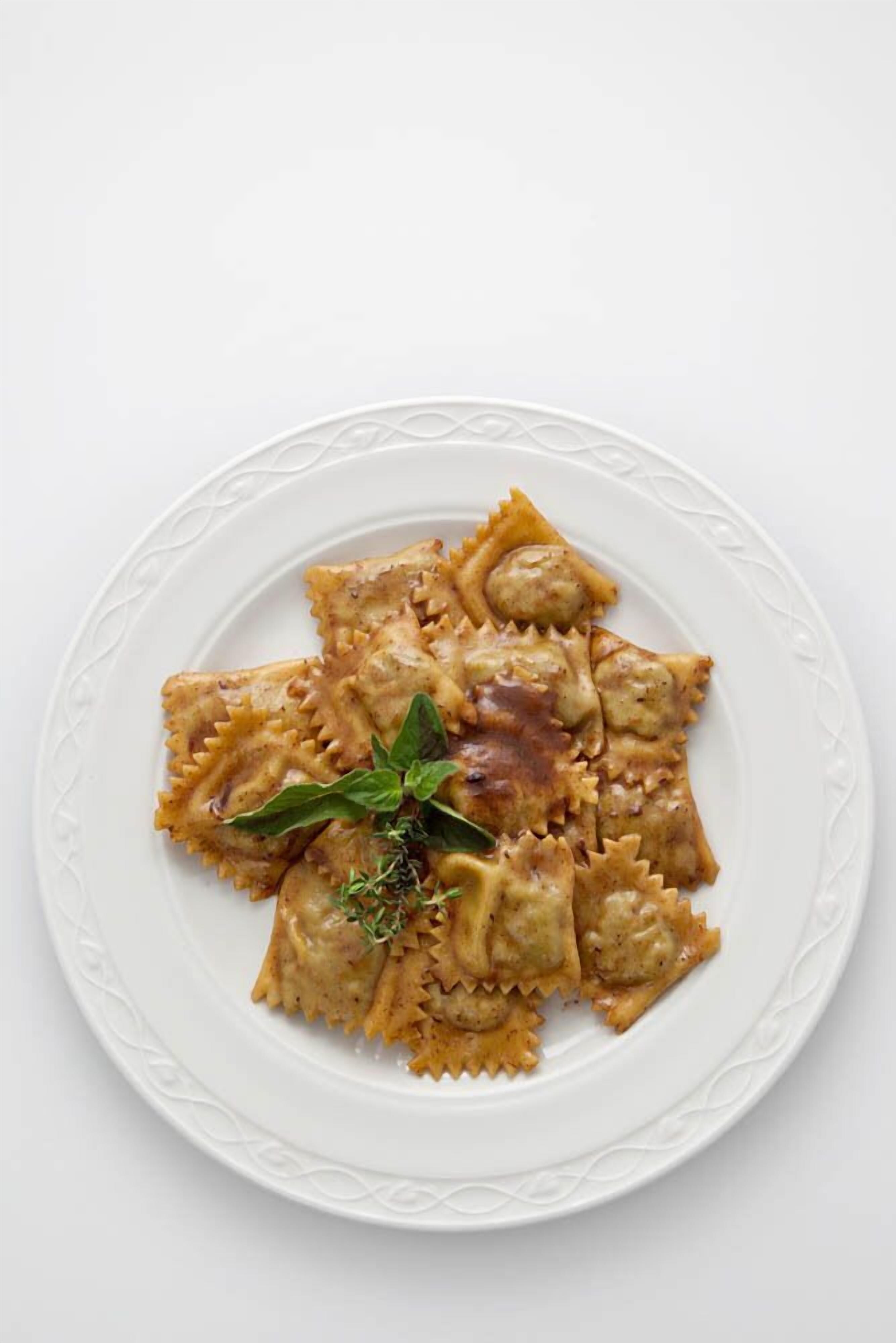 Un plato de ravioles decorado con hierbas.