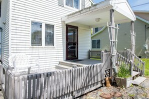 Step into this charming home with a cozy front porch featuring a bench and a potted plant.