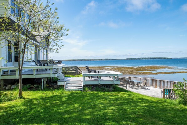 Relax on the deck overlooking the serene lake with comfortable outdoor furniture.