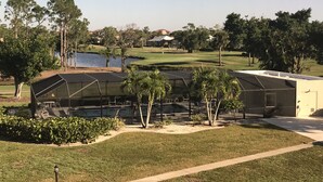 Ein Golfplatz mit Poolbereich, inklusive Liegestühlen und Sonnenschirmen.