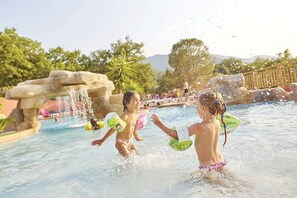 Ein Wasserpark mit Pool, Wasserspielen und einer Holzterrasse.