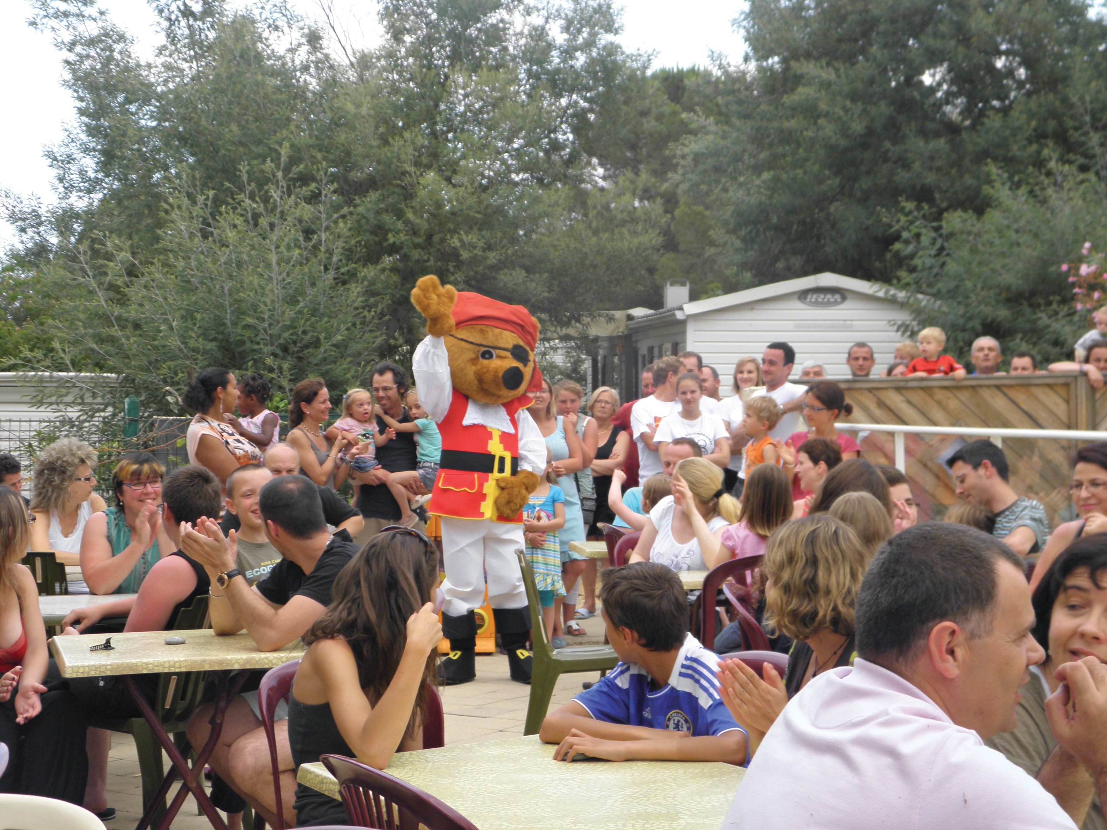 A mascot performing in front of a crowd at an outdoor event.