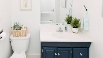 Bañera con ducha, secador de pelo, toallas, shampoo