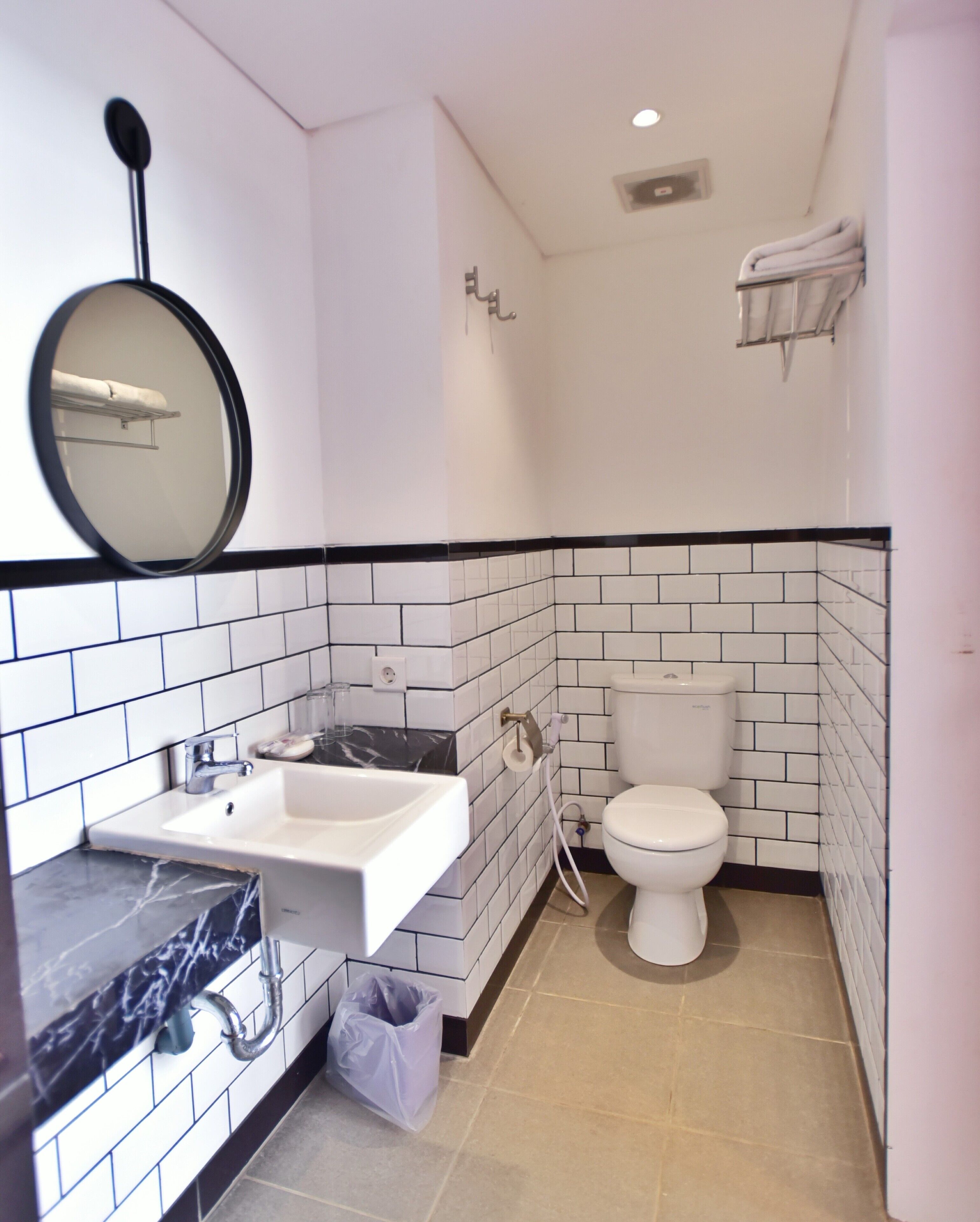 A bathroom with a white sink, a toilet, and a mirror.