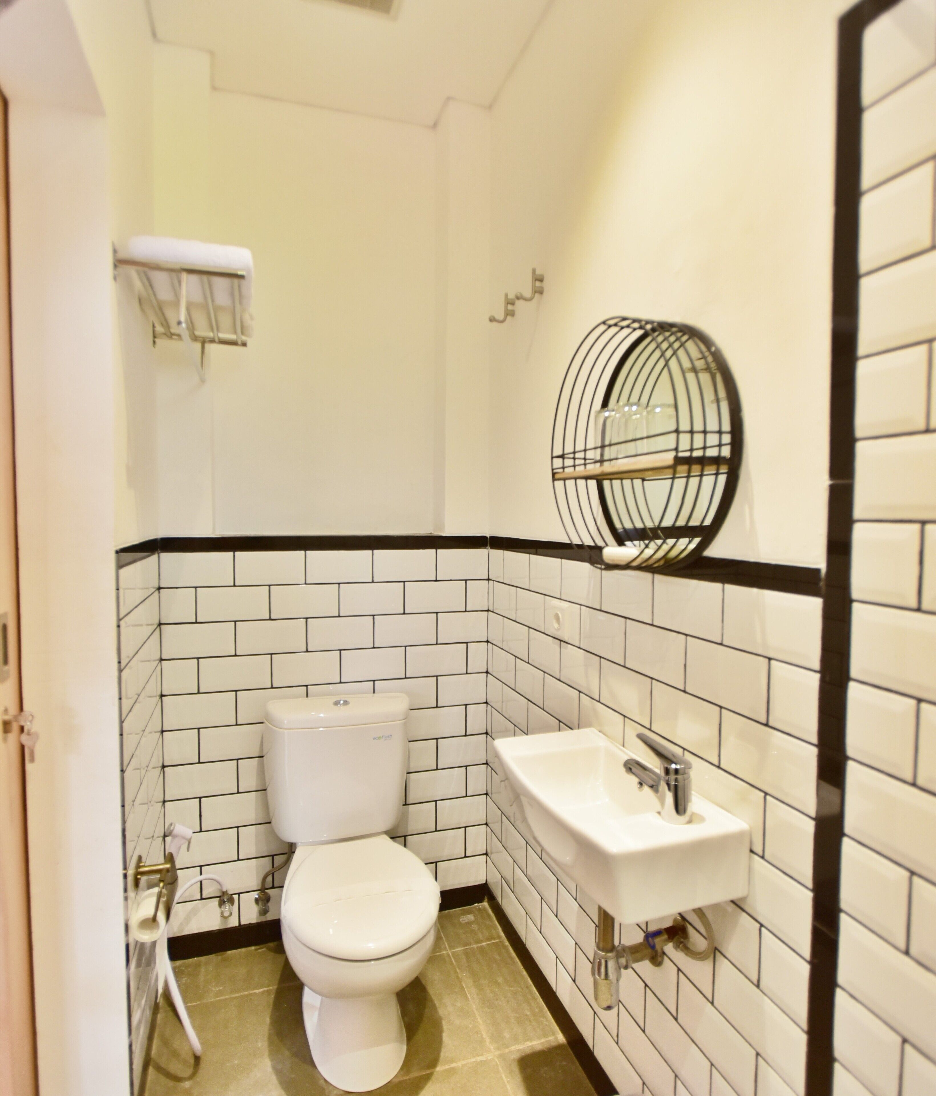 A bathroom with a toilet, sink, and a mirror.