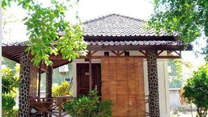 Ein traditionelles japanisches Haus mit Ziegeldach, Holzsäulen und einer kleinen Veranda.