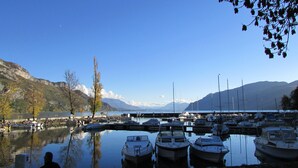 A marina with boats docked, surrounded by mountains and clear skies.