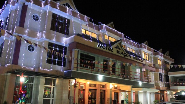 Un hotel con fachada de dos pisos, varios balcones y una decoración de árbol de Navidad.