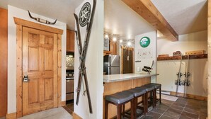 Eine Küche mit Holzausstattung, einem Kühlschrank, einem Herd und einer Theke mit Barhocker.