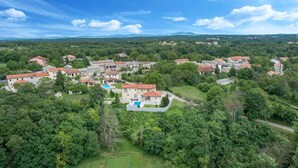 A residential area with multiple houses, a swimming pool, and lush greenery. - Villa Coridigo (Tinjan)