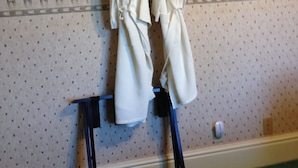 A room with patterned wallpaper, a wooden paddle, and towels hanging on a rack. - Angel House B&B (Clearview)