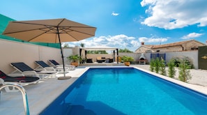A swimming pool with lounge chairs and a covered seating area. - Villa Martin (Tinjan)