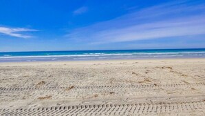 A sandy beach with footprints leading to the water.