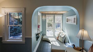 Ein gemütliches Zimmer mit einem bogenförmigen Fenster, einer Sitzbank und einer Lampe.