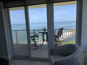 A balcony with a view of the ocean, a chair, and a small table. - Luxury Beach Penthouse with Incredible Direct Gulf View (Fort Myers Beach)