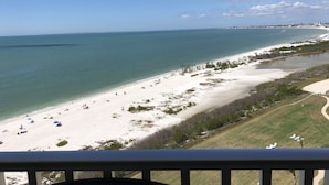 Een strand met heldere lucht en rustig water.