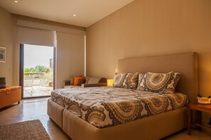 A spacious bedroom with a large bed, a sofa, and a small table.
