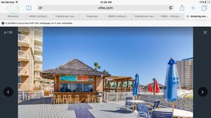 Una terraza de madera con mobiliario exterior y una zona de bar.